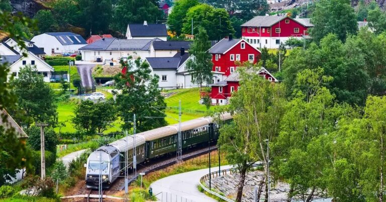 Scenic view of the Flåm Railway passing through a Nordic village.