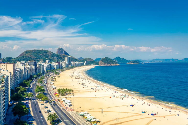 Aerial view of Copacabana Beach in Rio de Janeiro with mountains in the background