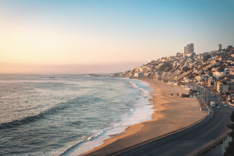 Viña del Mar coastline at sunset with cityscape and ocean.
