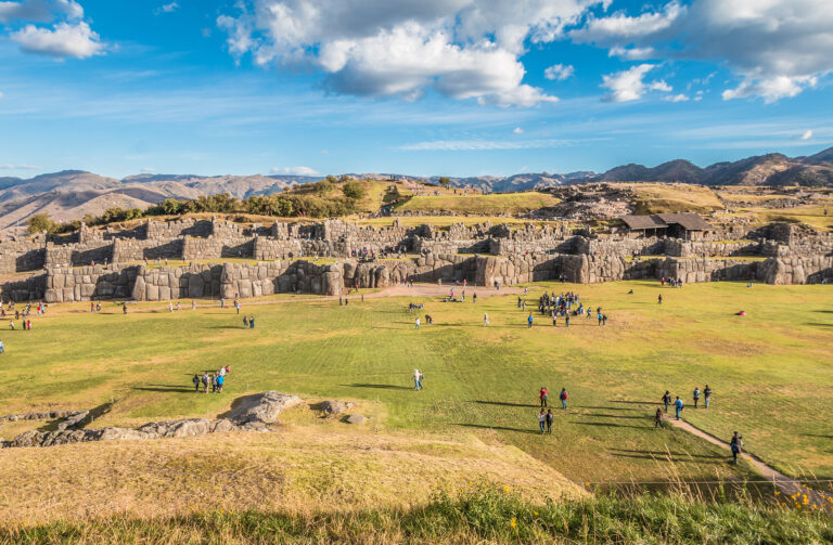 Tourists exploring the ancient ruins of Sacsayhuamán in Cusco.